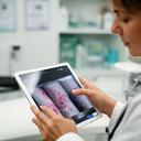 Telehealth medical director reviewing wound photos on a tablet in a private clinic office