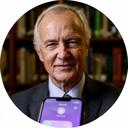 Senior solicitor using a secure messaging app while standing in a library lined with law books
