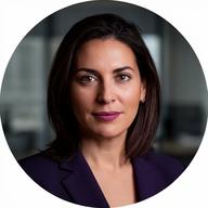 Professional headshot of Marina Cole in a dark blazer against a neutral office backdrop